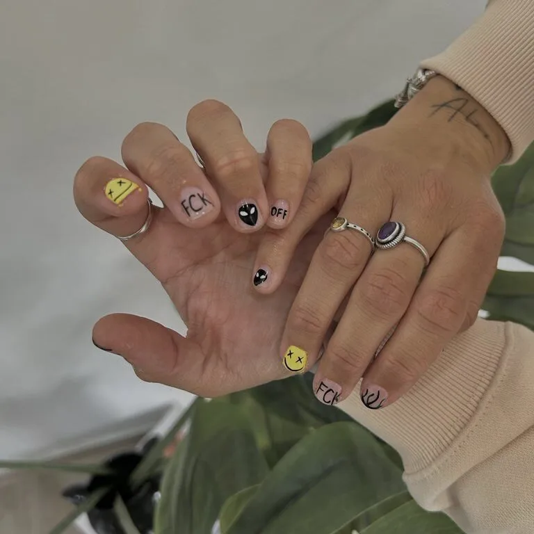Uñas cortas con caritas y símbolos