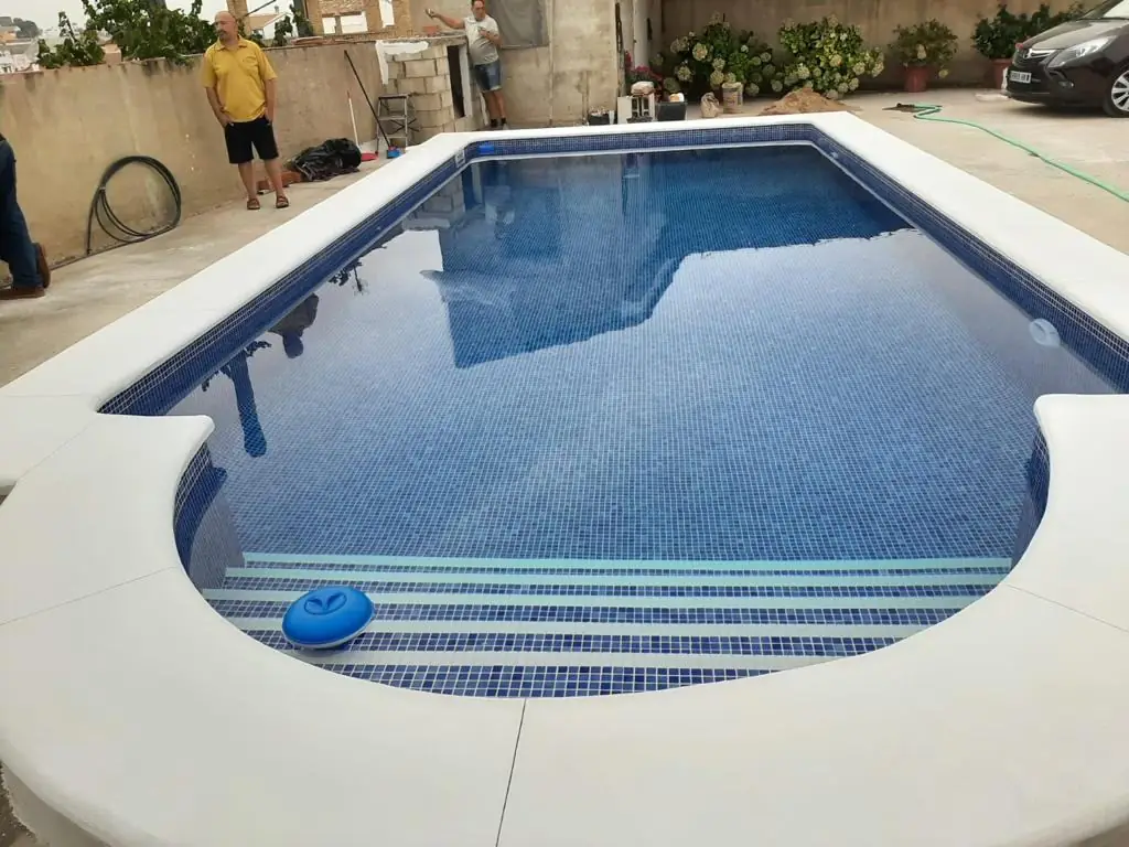 Piscina con escalera romana y gresite azul